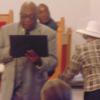 Pastor Collins reading certificates